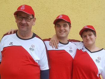 Ein Gruppenfoto: die zwei SportlerInnen mit ihrem Trainer