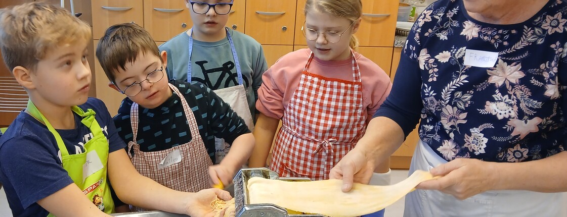 Kinder kochen mit einer Frau in einer Küche