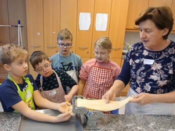 Kinder kochen mit einer Frau in einer Küche