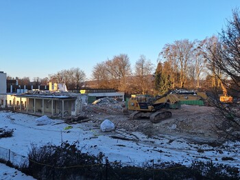 Hausabbruch im Winter mit Schnee und Bagger