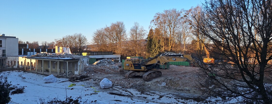 Hausabbruch im Winter mit Schnee und Bagger