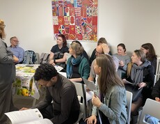 Mehrere Personen sitzen in einem Raum auf Stühlen.