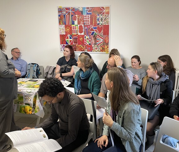Mehrere Personen sitzen in einem Raum auf Stühlen.