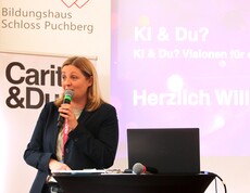 Caritas Präsidentin spricht auf der Bühne in ein Mikrofon.