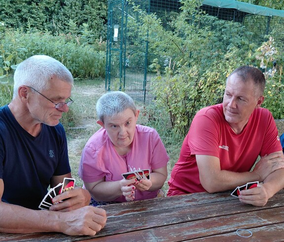 Drei Personen spielen Karten