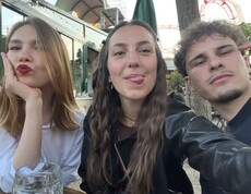 Zwei junge Frauen (eine mit Schmollmund und eine zeigt Zunge) und ein junger Mann schauen frontal in die Kamera