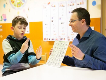 Luan und Hortleiter Wolfgang Holzinger beim Fingeralphabet. Eines der Interessen des Neunjährigen.