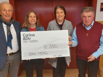 Foto von der Spendenübergabe. Vier Menschen lachen mit einem Spendenscheck in die Kamera.