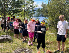 Action: Menschen handeln sich entlang eines Seils durch die Natur