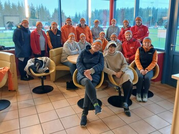 Das Team der mobilen Pflegedienste mit selbst gestrickten Hauben einer zufriedenen Kundin