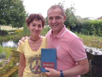 Eine Frau und ein Mann stehen zusammen und der Mann hält ein Büchlein in der Hand.