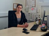 Eine Frau sitzt an ihrem Arbeitsplatz im Büro.