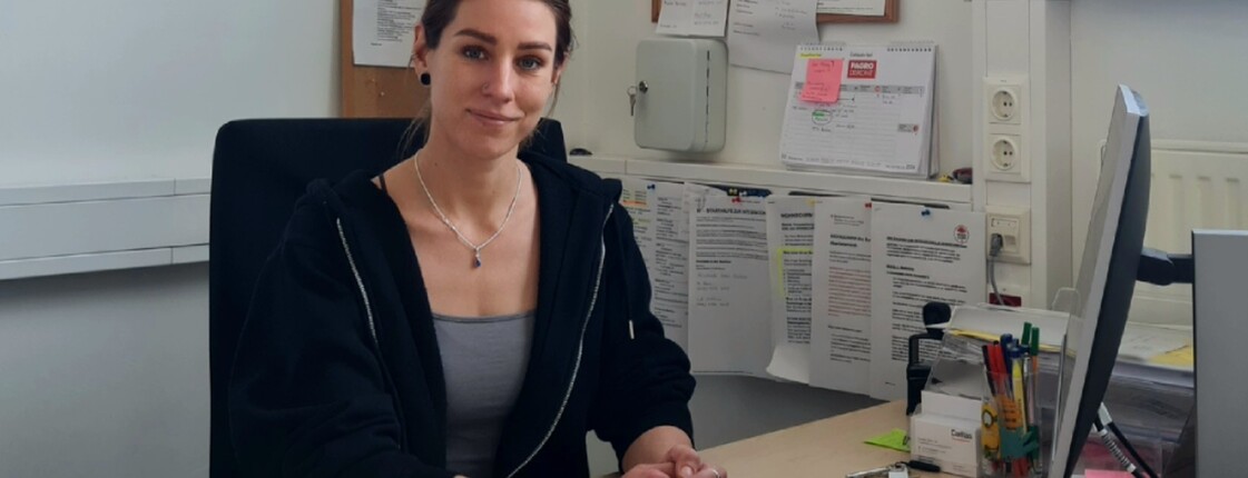 Eine Frau sitzt an ihrem Arbeitsplatz im Büro.