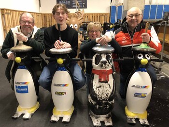 Vier Stockschützen mit Eislauf-Pinguinen