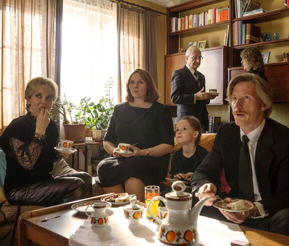 Familie sitzt mit Großeltern an einem Tisch