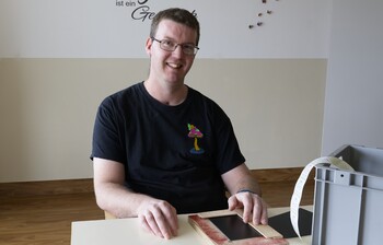 Portraitbild von einem Mann mit kurzen Jahren, Brille und schwarzen T-Shirt
