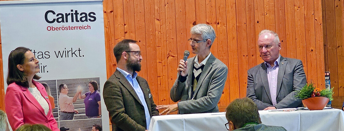 Personen die sich am Podium unterhalten.