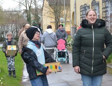 Kind hat das Osternest gefunden, daneben eine Frau