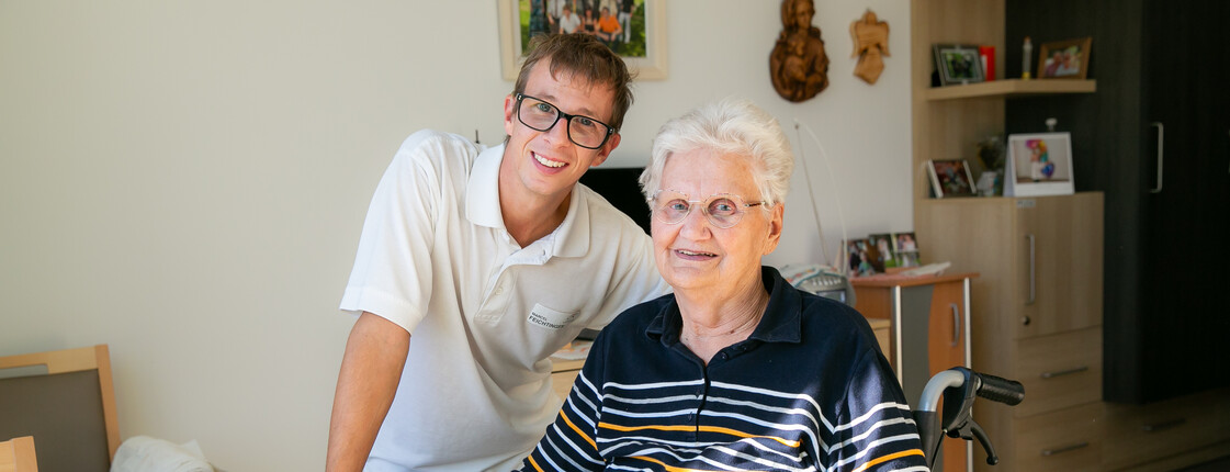 Integrative Beschäftigung 2 Personen lachen in die Kamera, Frau im Rollstuhl