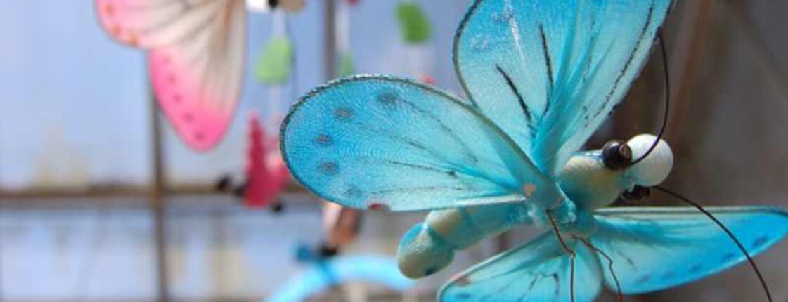 KinderPalliativNetzwerk Eine blauer und rosa Schmetterling hängen an einem Mobile.