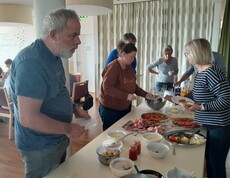 Leute bedienen sich beim Frühstücksbuffet.