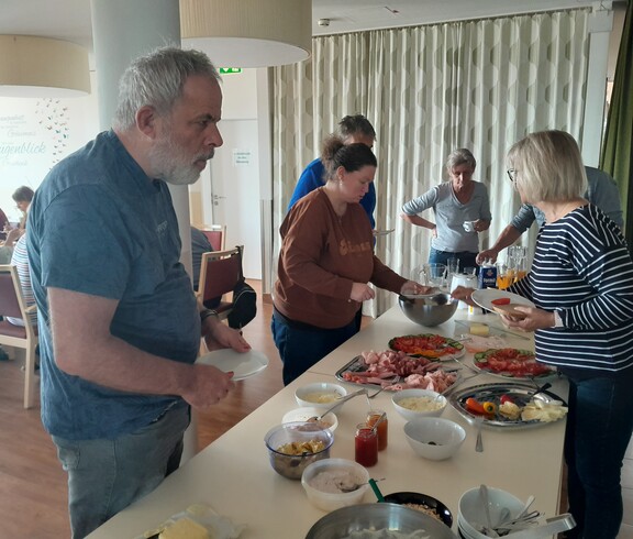 Leute bedienen sich beim Frühstücksbuffet.