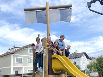 Kinder aus dem Caritas Hort auf einer Rutsche