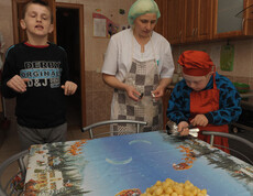 Kinder im Kinderdorf Gomel lernen unter Anleitung einfache Haushaltsaufgaben, wie das ordnungsgemäße Decken des Tisches und den Umgang mit Besteck.