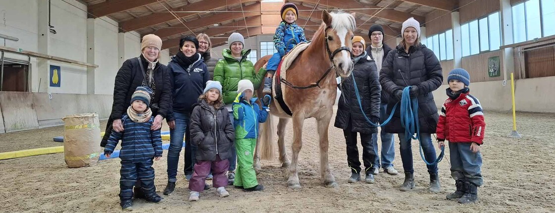 Pferd in der Reithalle mit vielen Personen 