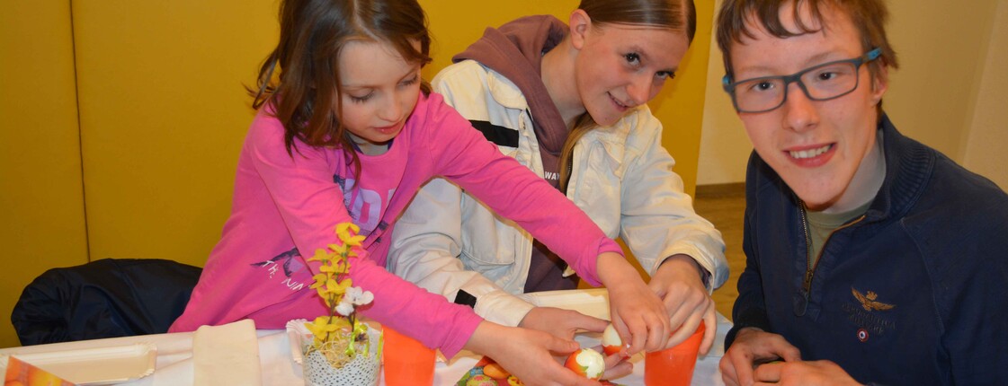 Drei Kinder beim Eierschälen