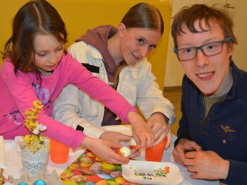 Drei Kinder beim Eierschälen