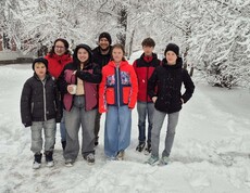Kinder- und Jugendgruppe in verschneiter Landschaft